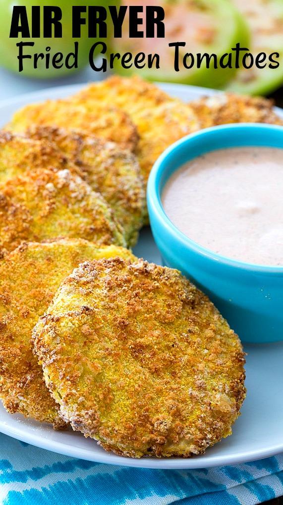 Green Tomato slices that have been fried on a plate with dipping sauce.