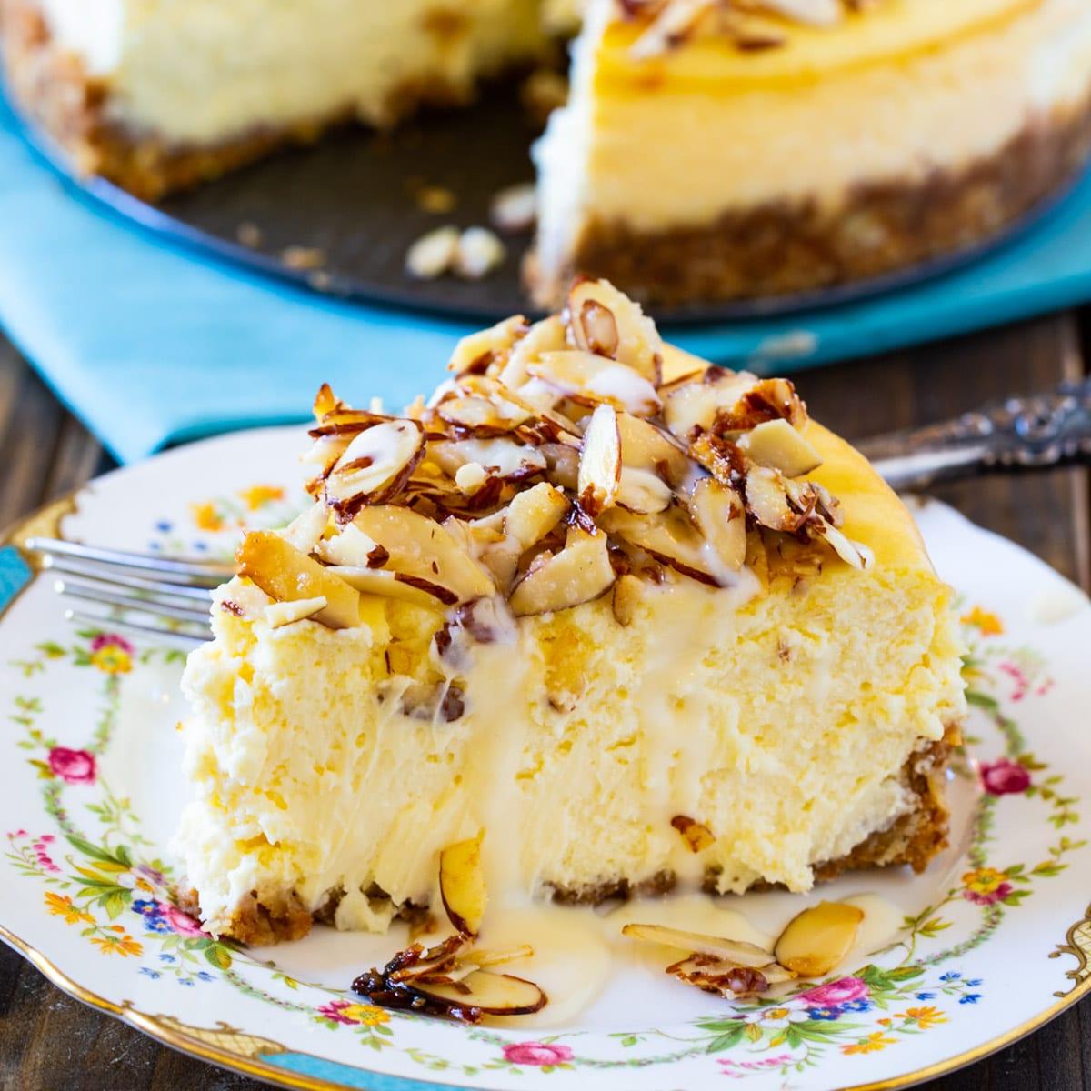 Slice of Amaretto Cheesecake on china plate.