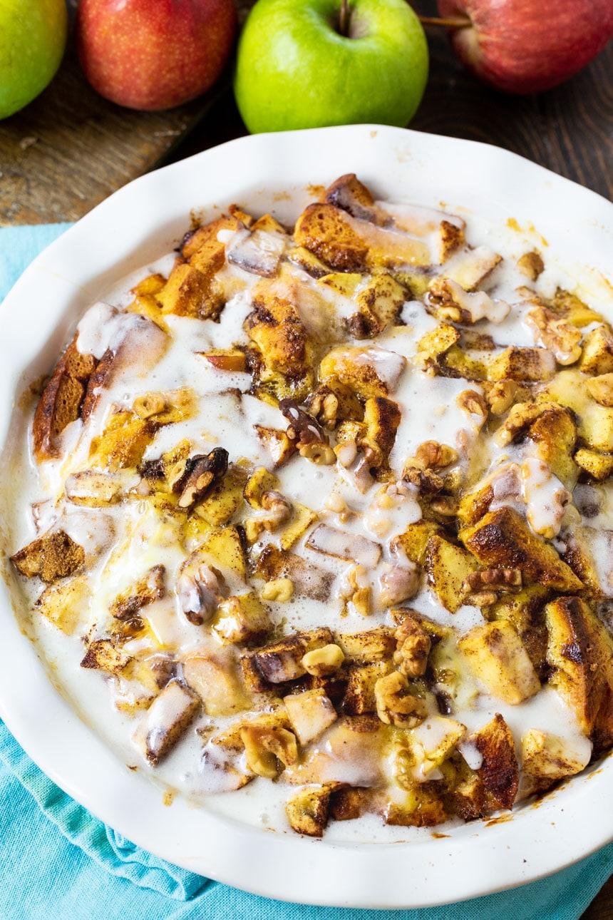 Apple Cinnamon Roll Bake in pie pan surrounded by apples.