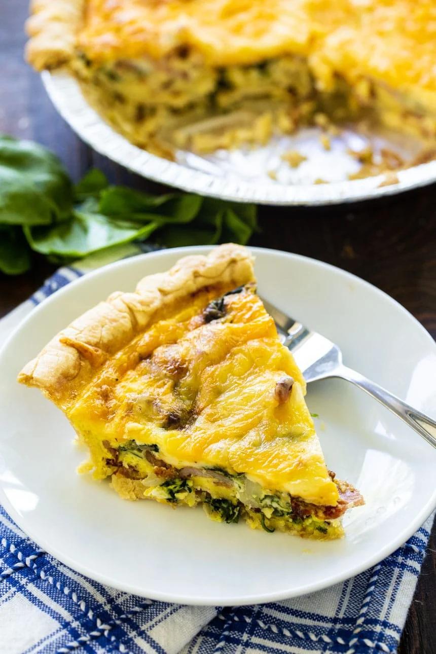 Florentine Quice slice on a plate with remaining quiche in background.