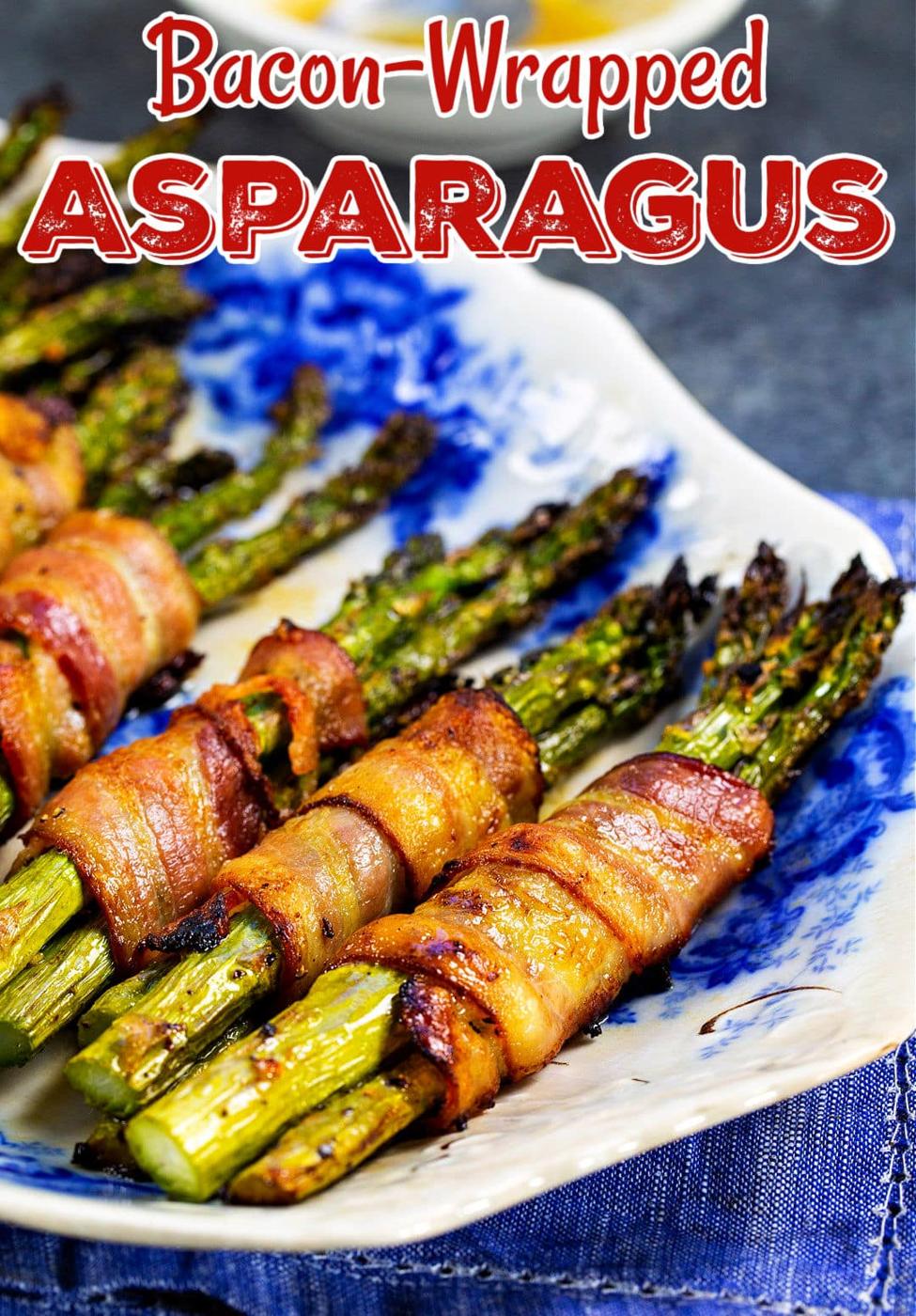 Bacon Wrapped Asparagus lined up on a plate.