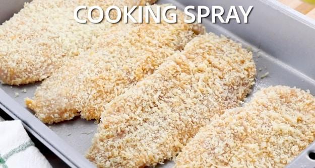 Spraying chicken with cooking spray.