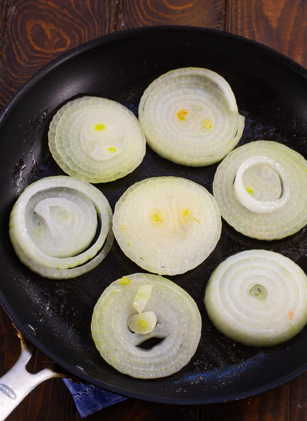 Onons being cooked in nonstick skillet.