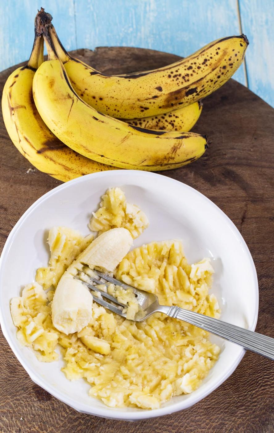 Banana getting mashed with a fork.