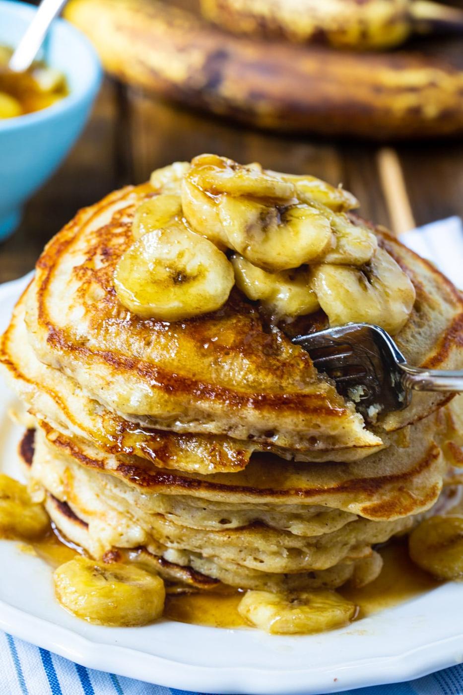 Fork cutting into stack of pancakes.