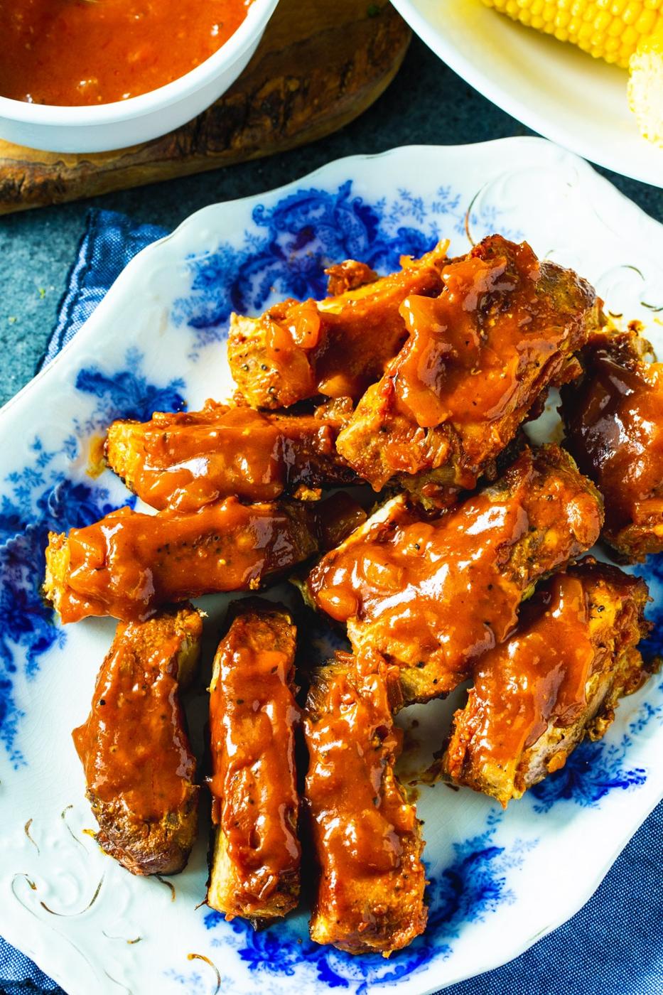 Individual Ribs coated in sauce on a serving platter.