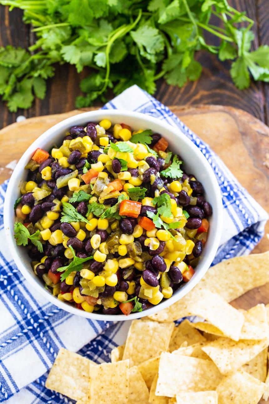 overhead shot of Black Bean and Corn Salsa with tortila chips and fresh cilantro