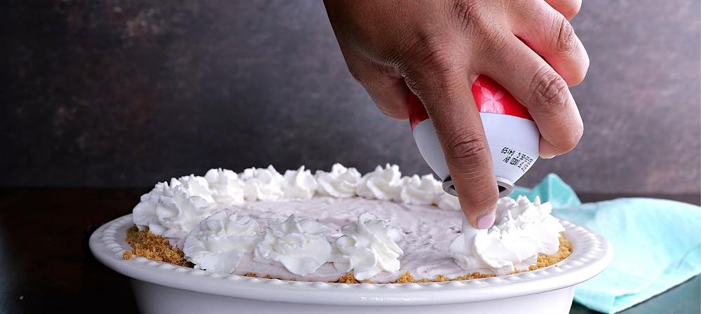 Decorating pie with whipped cream.
