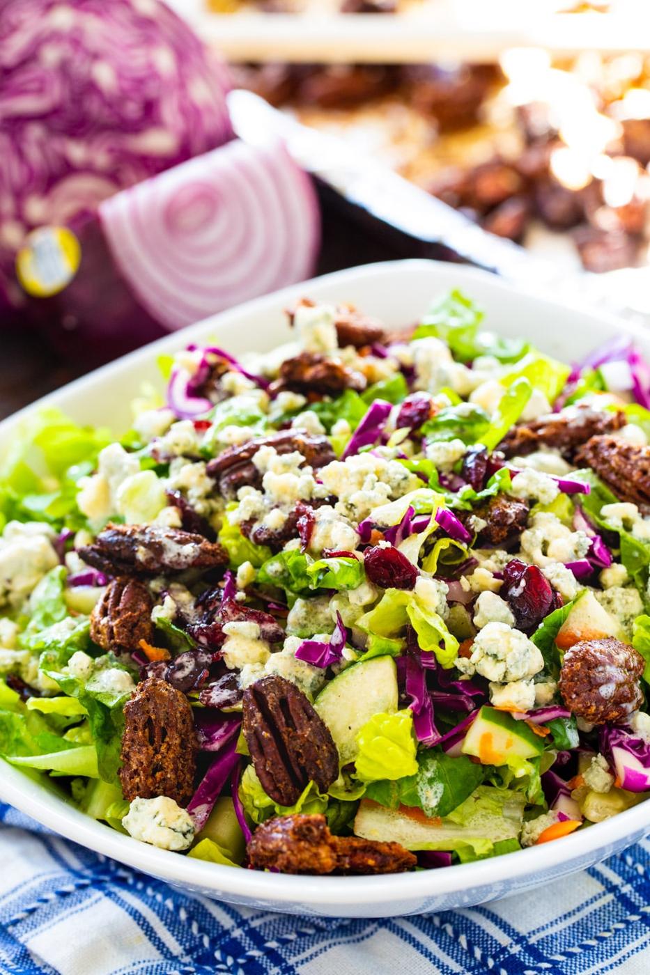 Chopped Salad in a large white bowl with cabbage in background.
