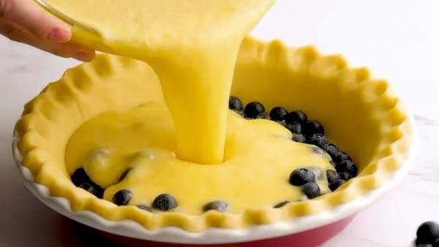 Pouring batter into crust.