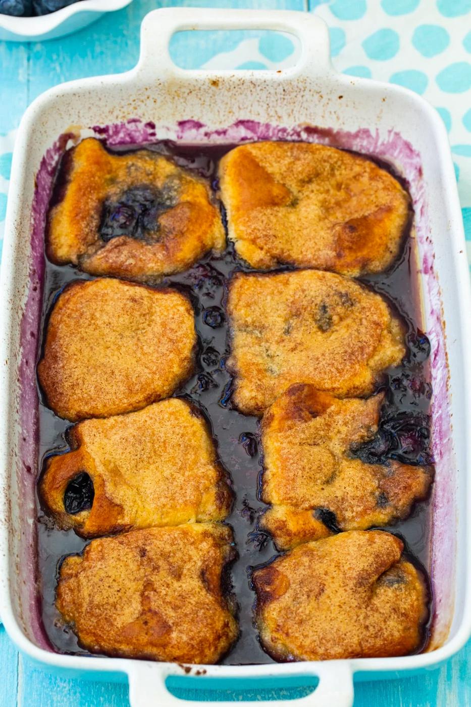 Dumplings with blueberries in a baking dish.