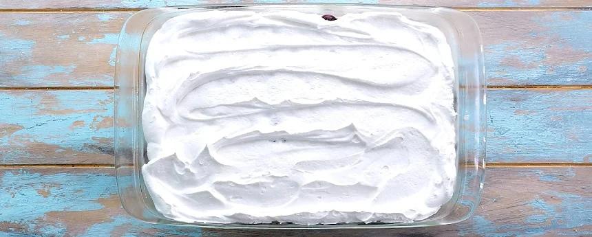 Spreading Cool Whip on top.