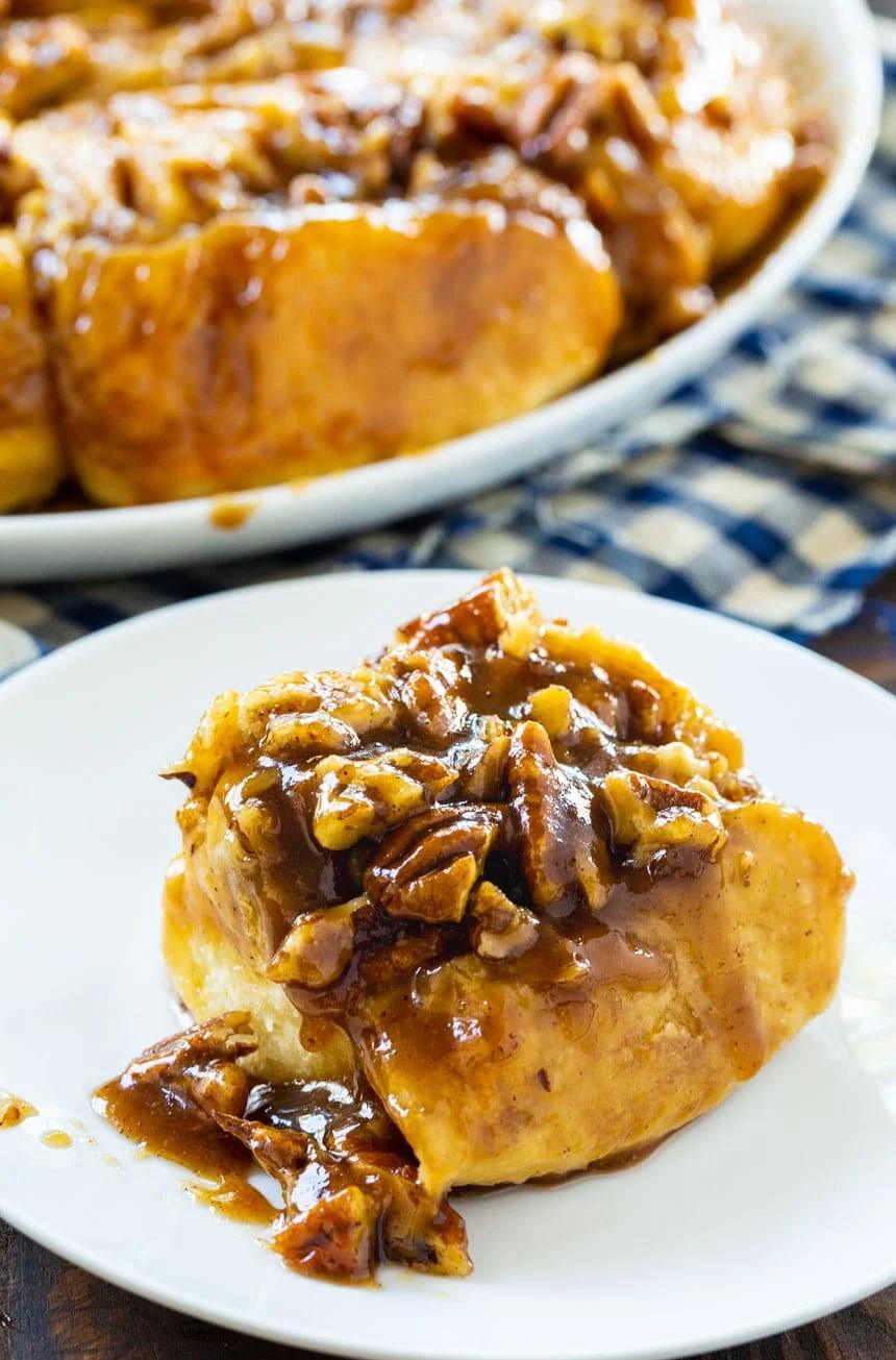 A Bourbon Pecan Cinnamon Roll on a small white plate