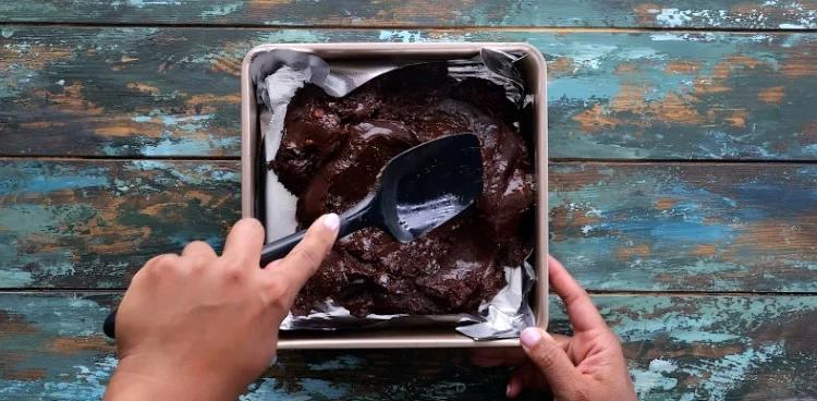 Spreading fudge mixture out in pan.