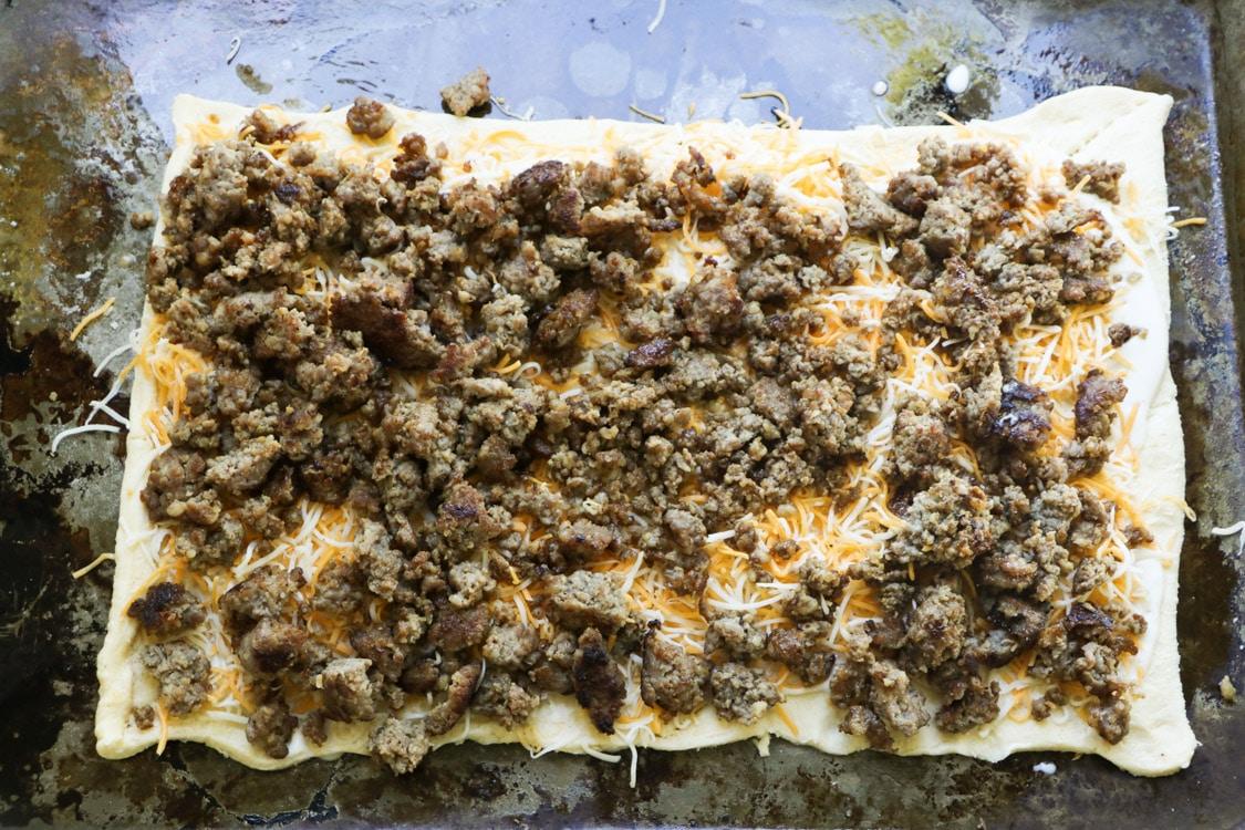 Sausage and cheese placed on crescent dough.