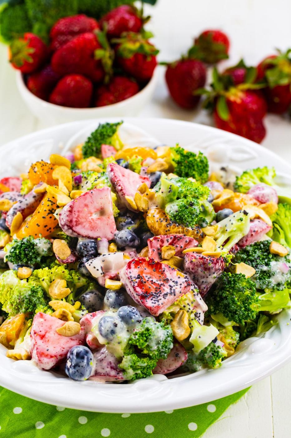 Broccoli Strawberry Salad in bowl with fresh strawberries in background.