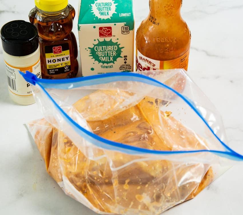 Ingredients and chicken in marinade.