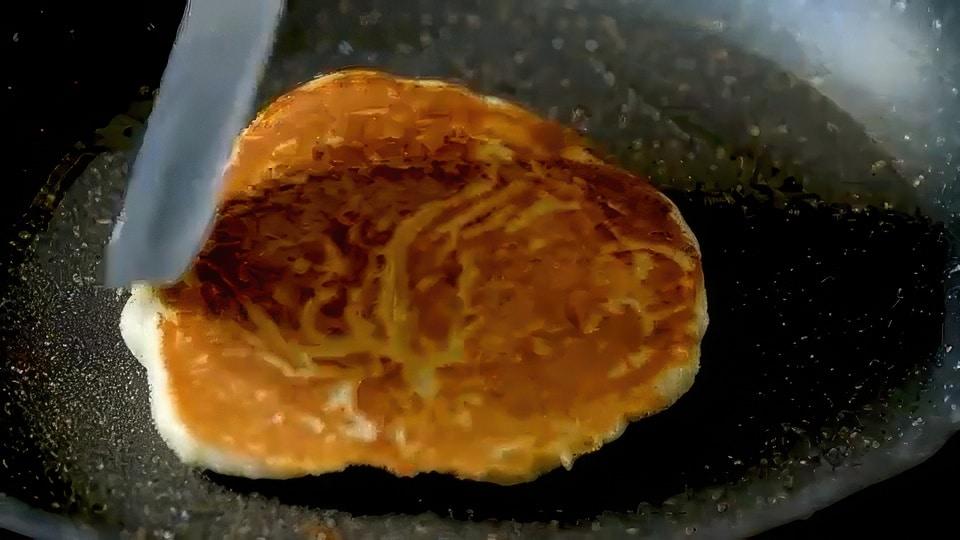 Cooking pancake in skillet.