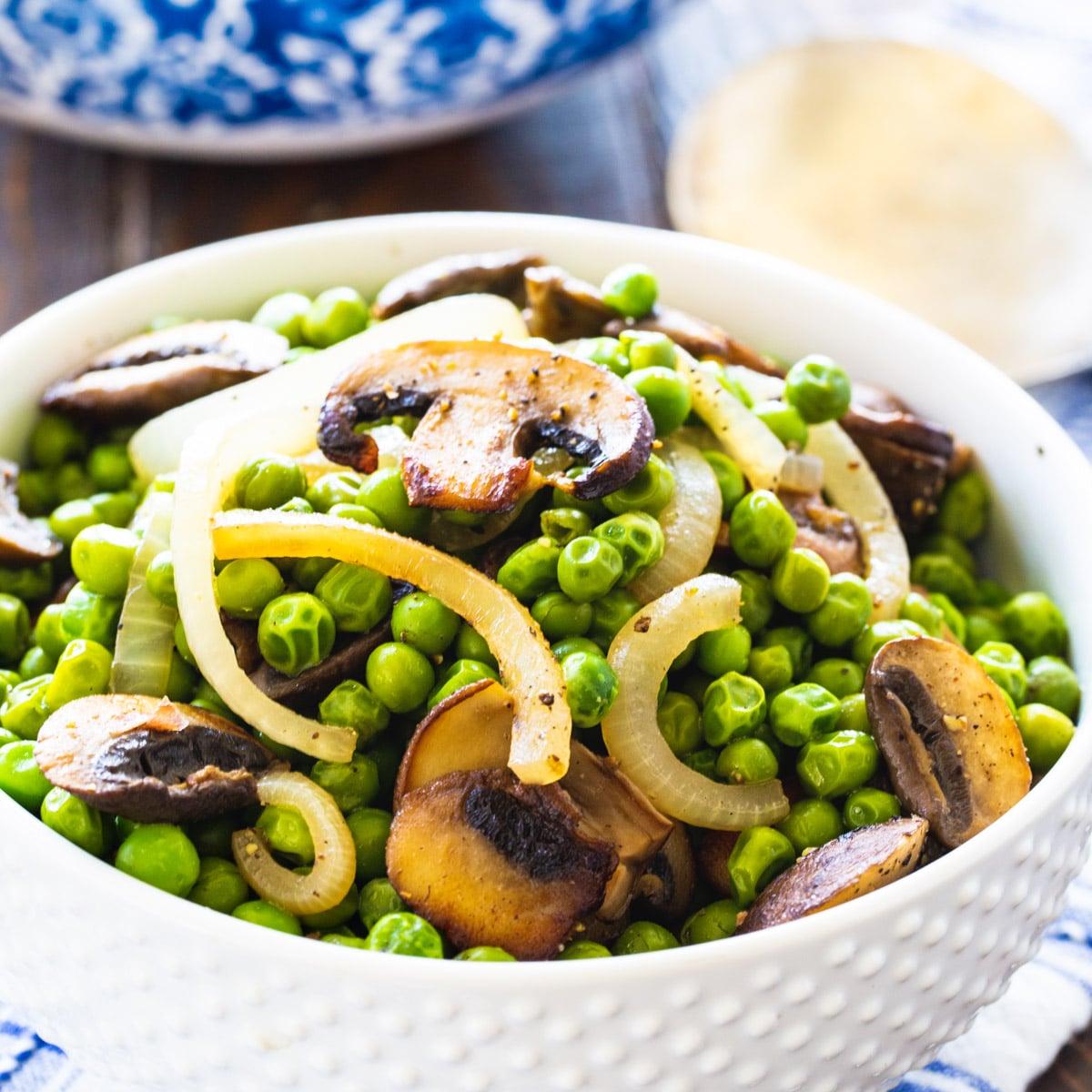 Buttery Peas and Mushrooms in a white bowl.
