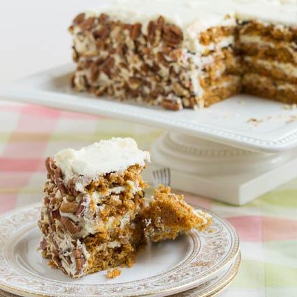 A slice of Carrot Layer Cake on a plate with a bite cut out.