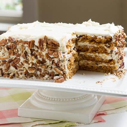 Carrot Cake with chopped pecans on the sides.