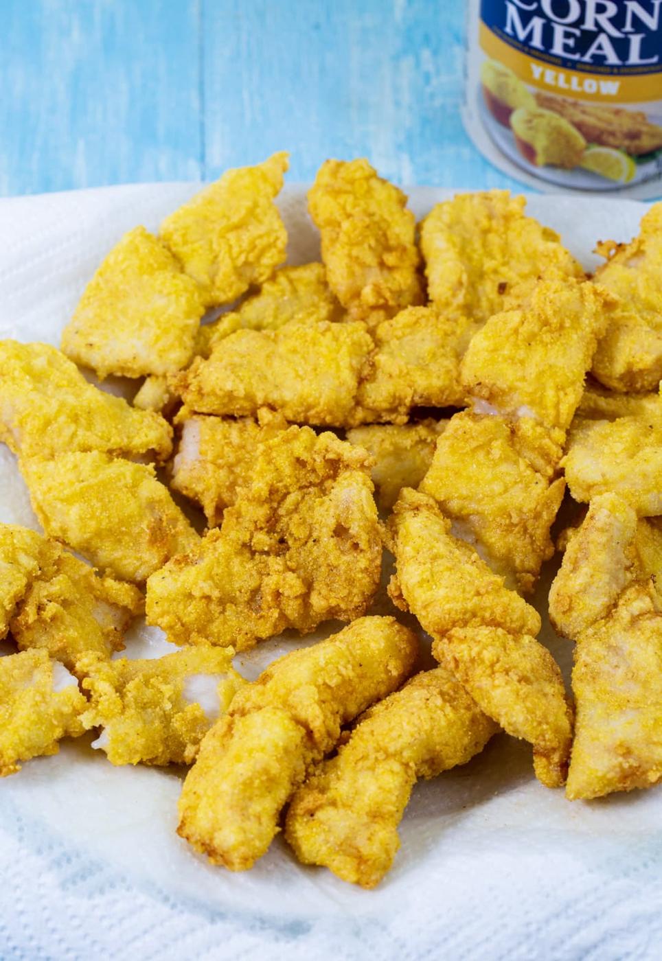 Fried catfish pieces on paper towel-lined plate.