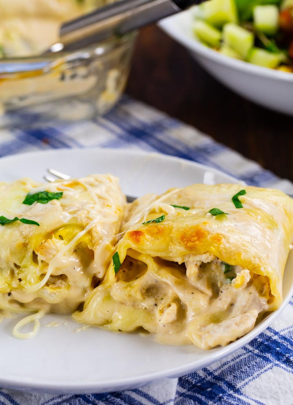 Two Chicken Alfredo Lasagna Roll-Ups on a plate.