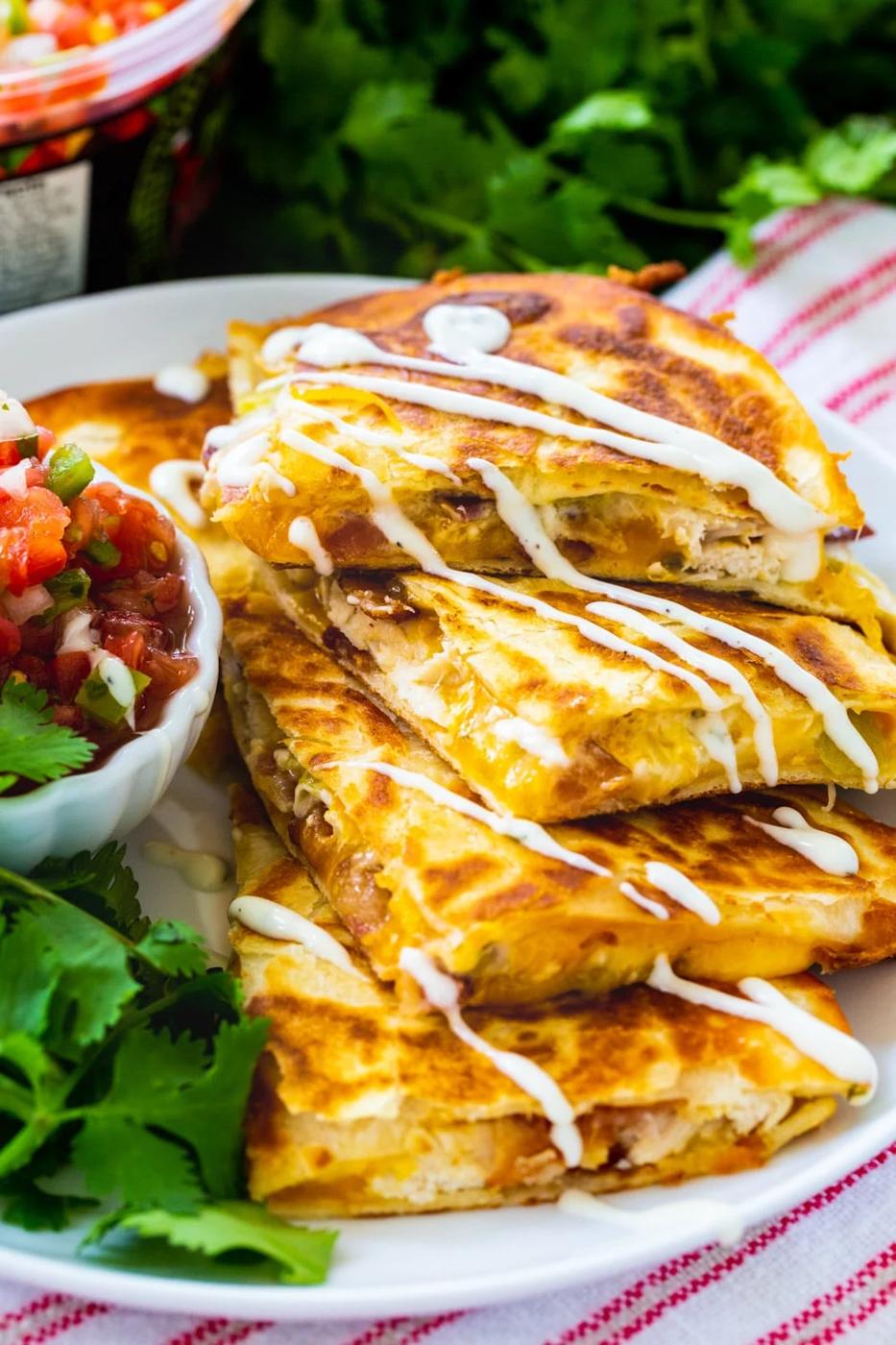 Chicken, Bacon and Ranch Quesadillas drizzle with ranch on a plate.