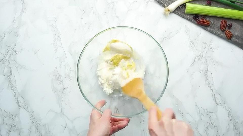 Mixing together cream cheese, mayo, and mustard.
