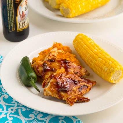 Root Beer Glazed Chicken on a plate with a jalapeno and corn on the cob.