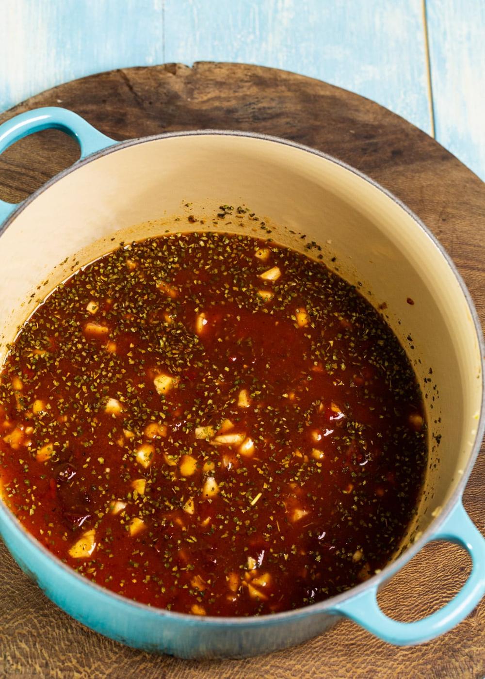 Ketchup and chipotle peppers mixed together in Dutch oven.