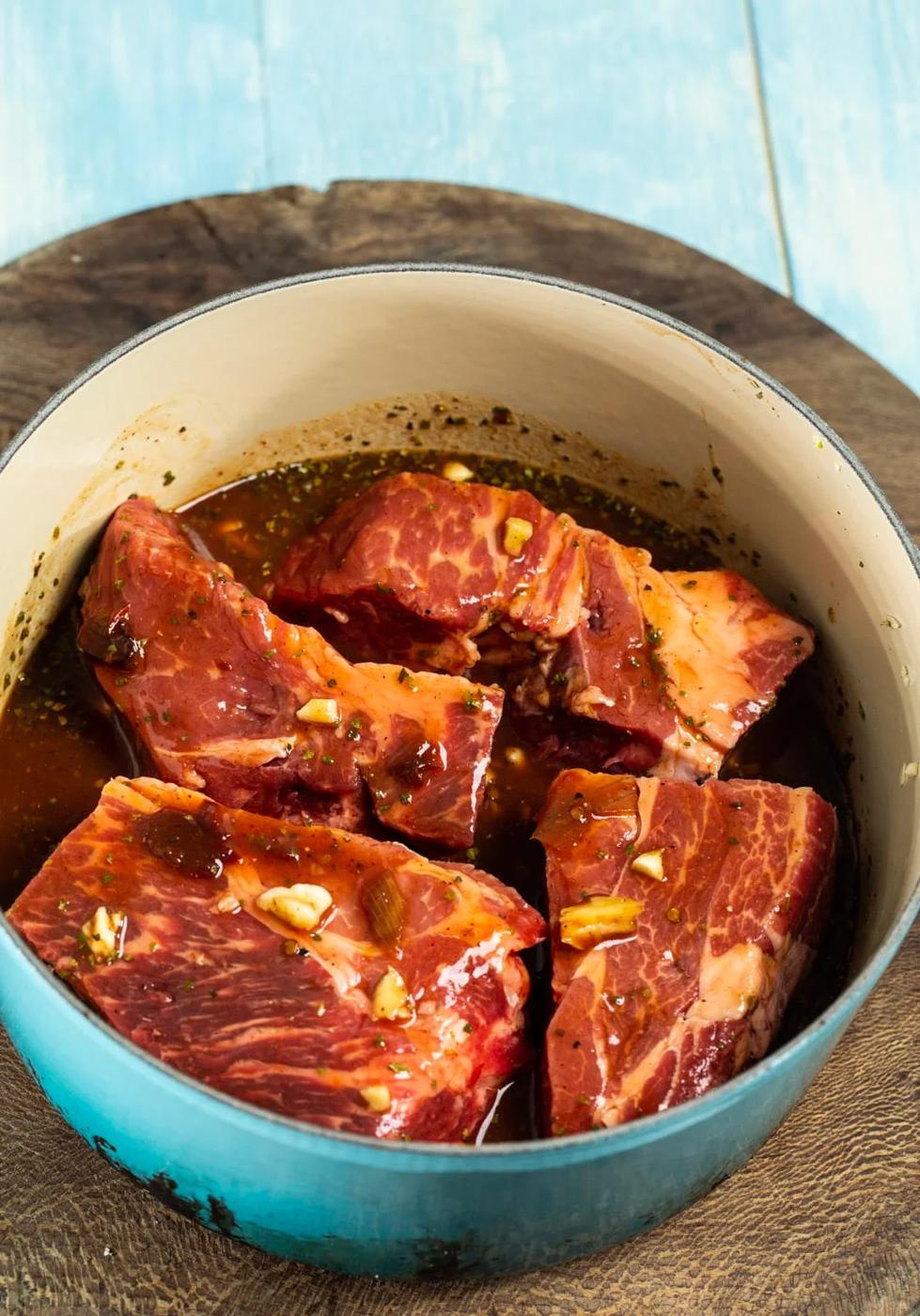 Uncooked chuck roast coated in sauce.
