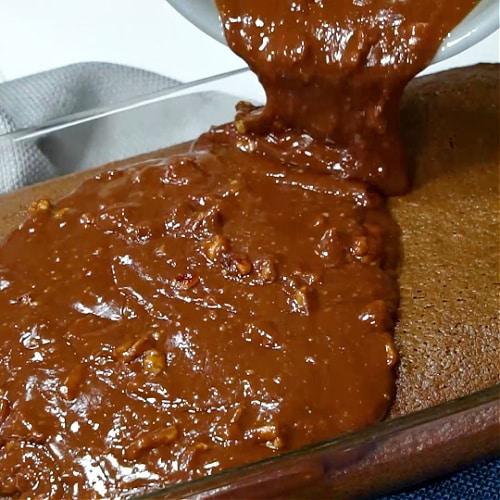 Pouring frosting on cake.