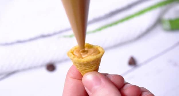 Filling bugle with peanut butter.