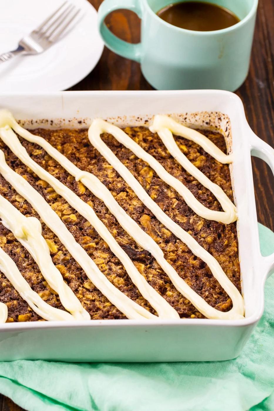 Baked Oatmeal topped with cream cheese glaze in a baking dish.