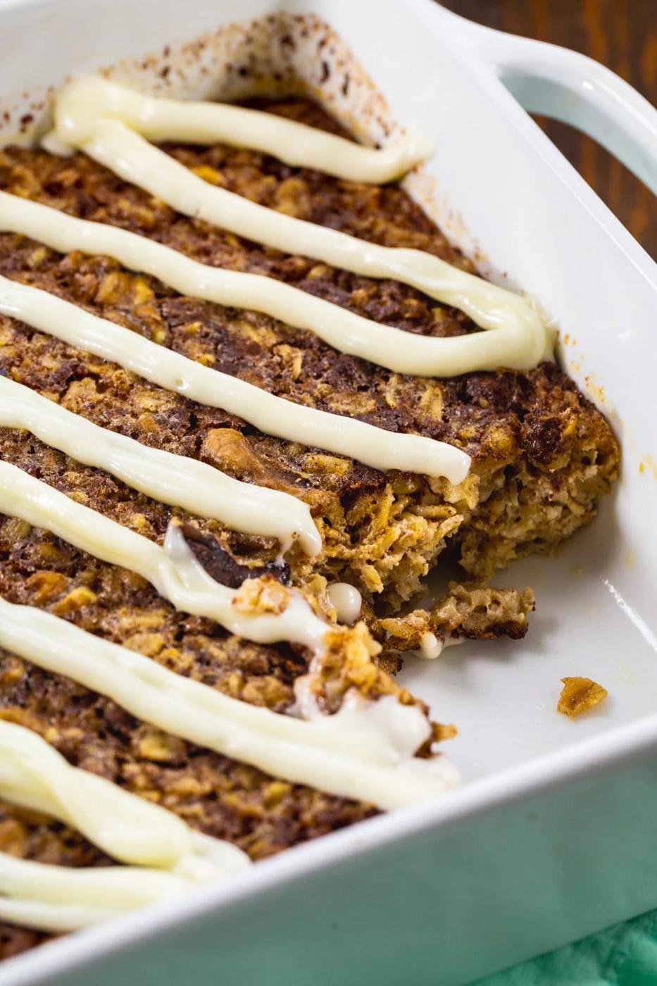 Cinnamon Roll Baked Oatmeal in baking dish with piece cut out.