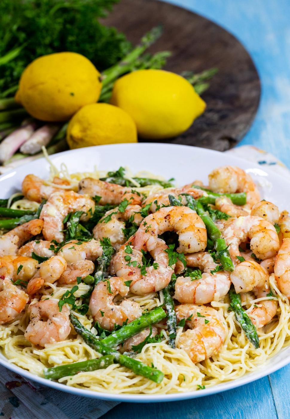 Shrimp Angel Hair Pasta in bowl and fresh lemons in background.