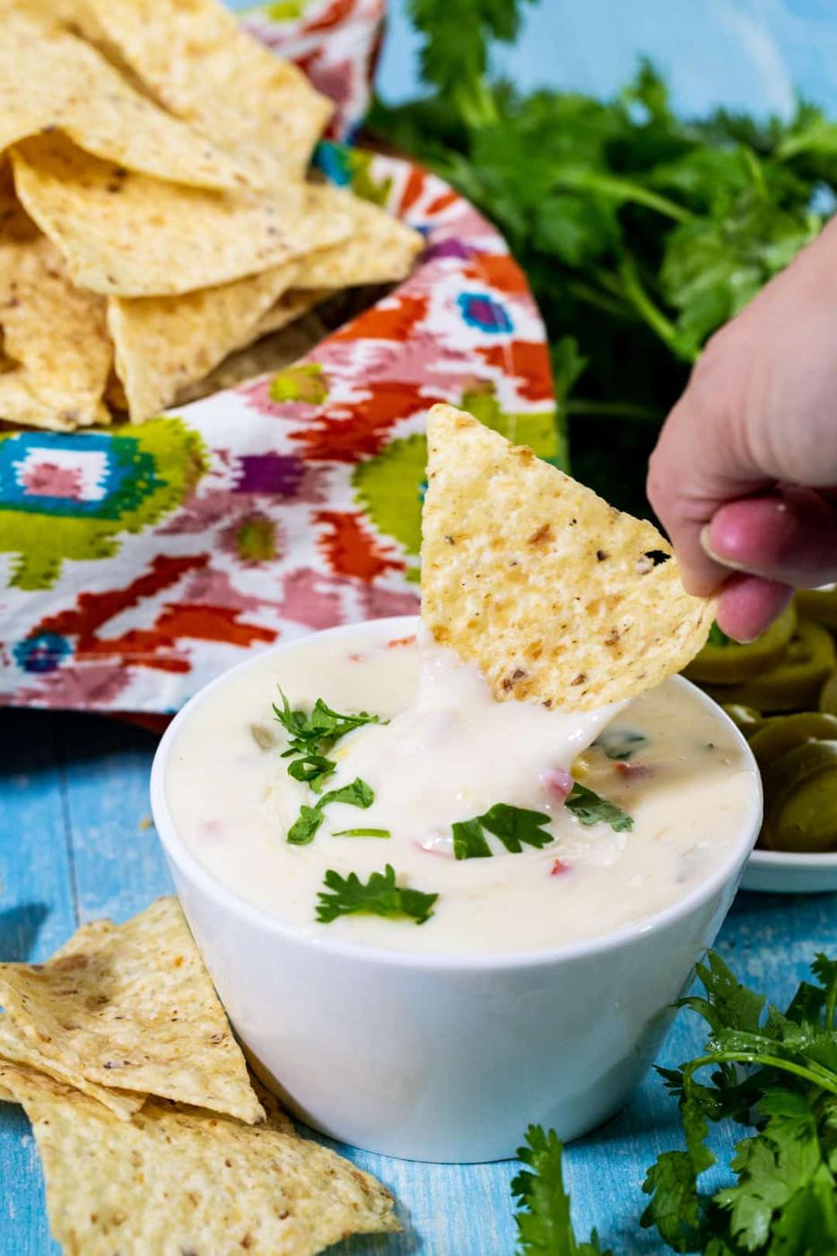 Chip dipping into queso.