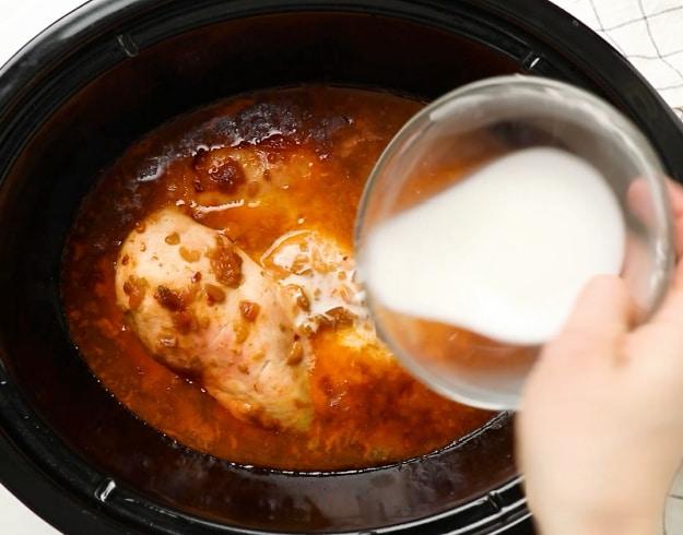 Adding cornstarch mixture to slow cooker.