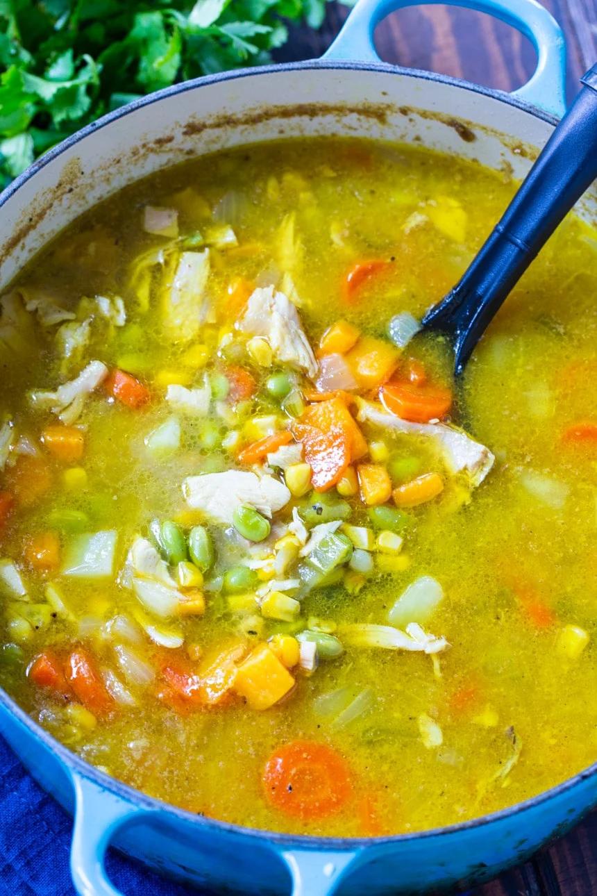 Dutch oven full of chicken soup with curry.