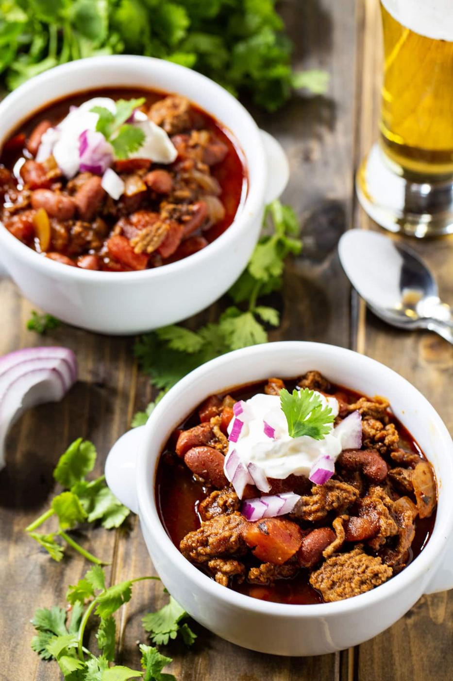 Dr Pepper Chili in 2 bowls and a glass full of beer.