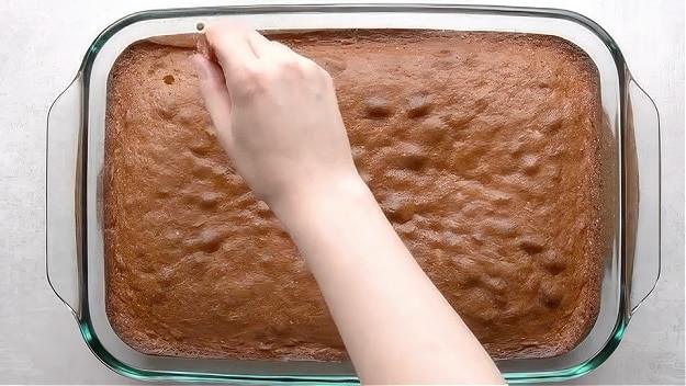 Poking holes in cake.