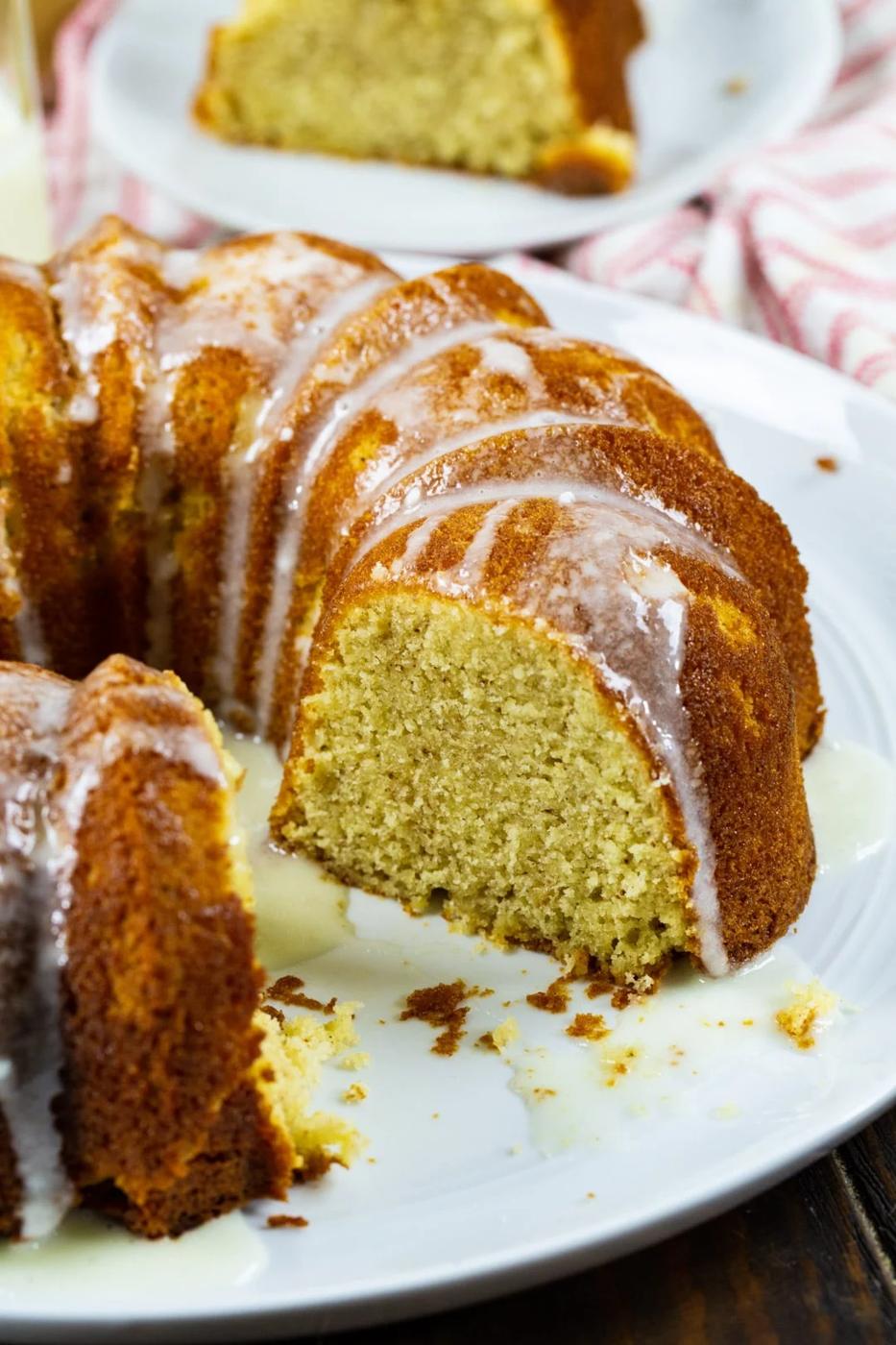 Whole pound cake with a slice cut out on a serving plate.