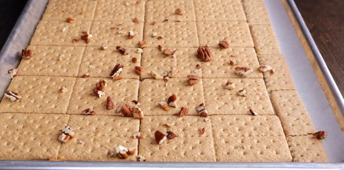 Sprinkling pecans on top.
