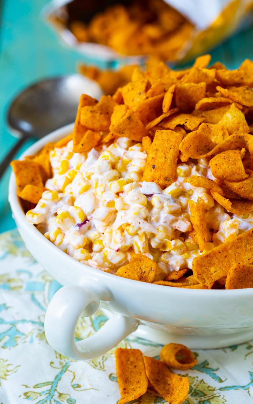 Frito Corn Salad topped with Frito chips in a bowl.