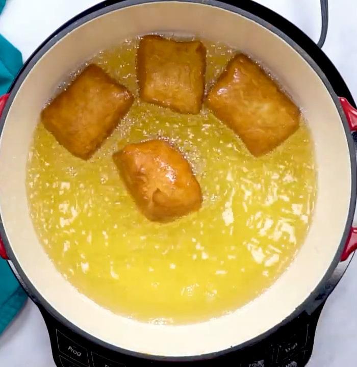 Beignets frying in oil.
