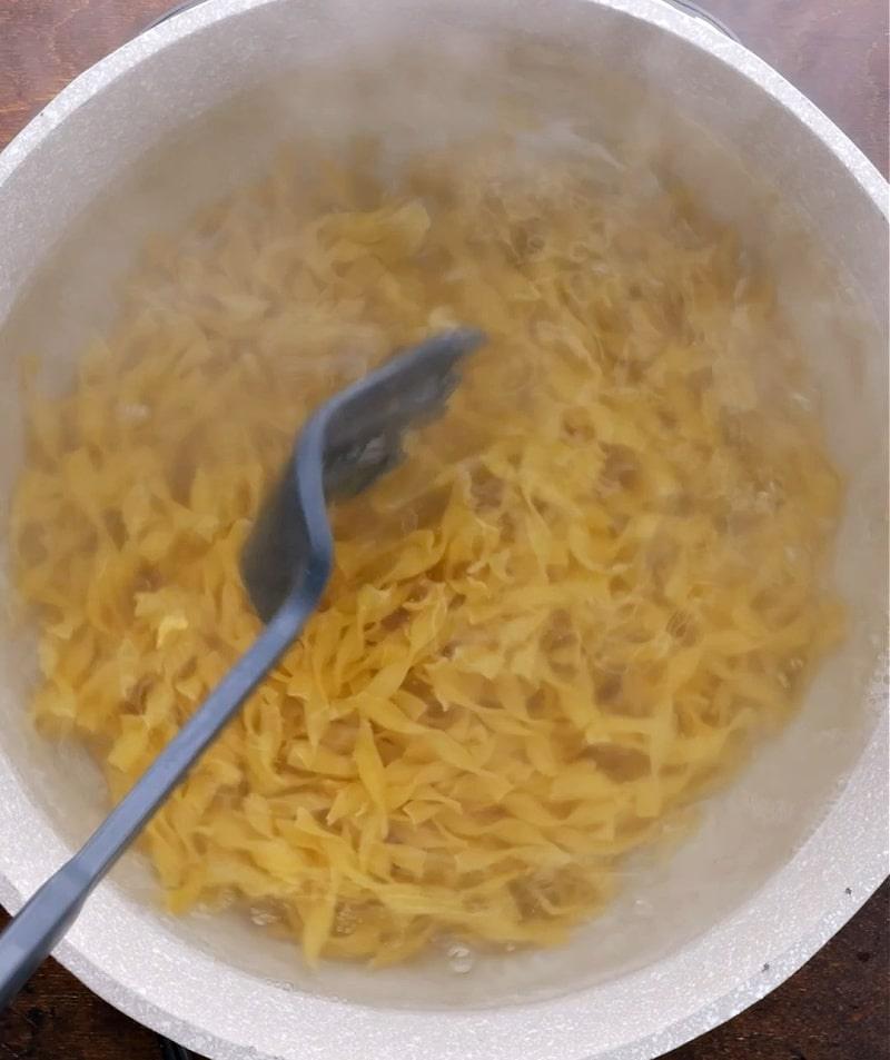 Noodles cooking in pot.