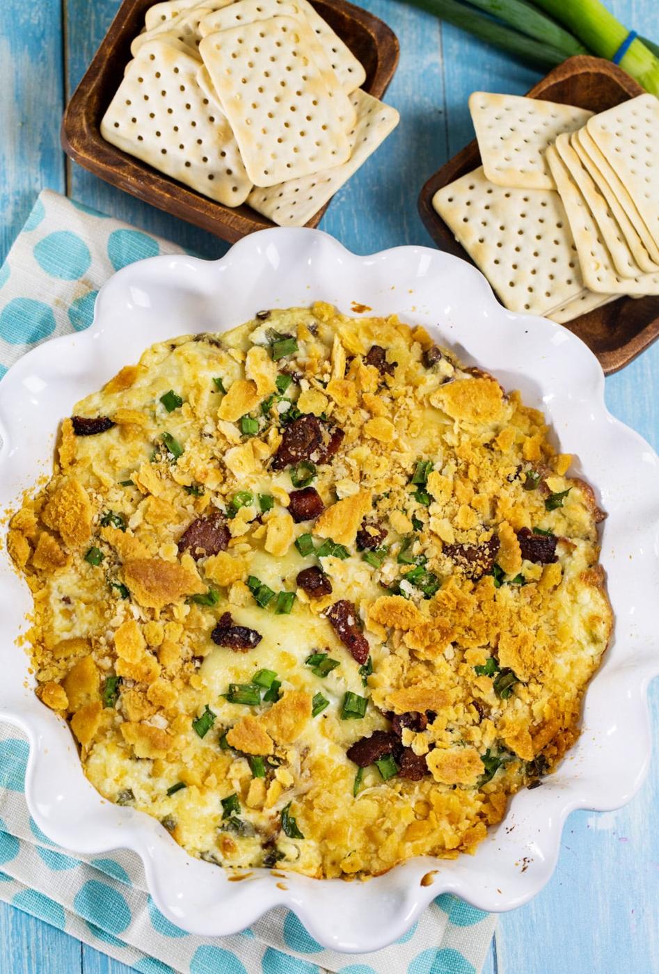 Bacon Swiss Dip surrounded by crackers.