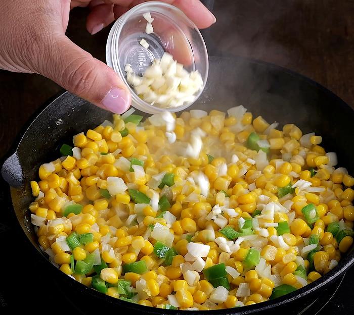 Adding garlic to corn mixture.