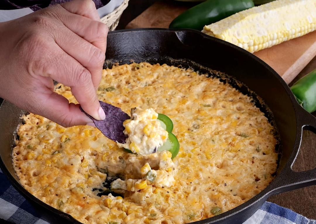 Chip dipping into spicy corn dip.